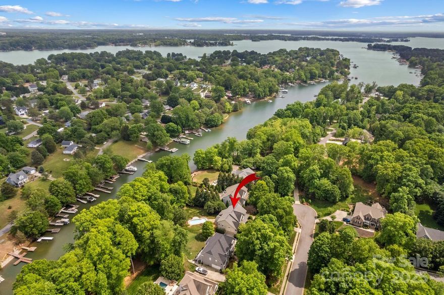 Live an ultimate Lake Norman lifestyle in this waterfront basement home w/dock & pool! In a desirable community, this Southern charm beauty welcomes you starting at a rocking-chair porch & soaring 2-story foyer. Functional layout on three spacious levels. Open kitchen is a chef’s dream featuring a cozy breakfast area w/rustic wood beams. 2-story GR & formal LR both offer warm gas fireplaces—perfect for relaxing/entertaining. Need an office or main-level guest suite? You’ve got it w/the flexible 5th bed option. Retreat upstairs to expansive primary suite w/ a serene sitting area & dual walk-in closets. 3 additional bedrooms are generously sized—one ensuite. Basement is ready for fun w/new LVP floors, full bar, massive rec room, flex space, & full bath—ideal for game/movie nights or hosting guests. Step outside to the private resort-style yard! Lounge on the new deck, splash in the pool, gather at the firepit, stroll to your dock w/boat lift. Enjoy the waterfront lifestyle you dream of!