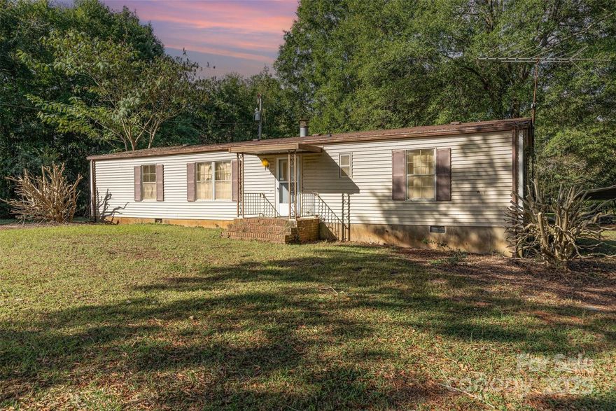 Set on 3.8 acres in Midland, this property isn’t just a place—it’s a canvas for the life you’ve imagined. Rolling, usable land gives you room to breathe and room to dream, whether that’s a custom estate tucked beneath big Carolina skies or a multi-home compound for the people you love. The current mobile home, situated on continuous footing, offers livable space now, so you can plan, design, and build on your timeline. On-site improvements jump-start your vision: a 30×30 carport for vehicles or equipment, a solid block building that begs to be your very own workshop or studio, and a storage shed to keep projects organized.

A second driveway along the left side adds easy access and future flexibility—think guest house, additional residences, or an expansive barn. Create gardens, carve out trails, welcome animals, and gather for golden-hour sunsets; the acreage invites a true indoor-outdoor lifestyle with privacy and possibility in every direction.

Opportunities like this are rare: land with utility, location, and ready-made infrastructure, waiting for your ideas to take root. Invest in a future that feels like you.