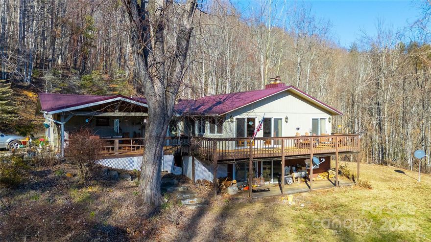 This private, wooded 5.30+/- acre property offers breathtaking long-range mountain views and a glimpse of the North Toe River just across the road. The spacious 4-bedroom, 4-bathroom home features an open floor plan with two primary suites on the main level, perfect for comfort and convenience. The finished basement provides additional living space, ideal for guests or entertainment. Step outside onto the large deck to soak in the peaceful surroundings and fresh mountain air. With no restrictions, this property offers endless possibilities—whether you're looking for a full-time residence, vacation home, or rental opportunity. Enjoy privacy while still being close to outdoor adventures, fishing, and local amenities. Don't miss this rare find in the heart of the mountains! No drivebys, must be accompanied by a licensed real estate agent.