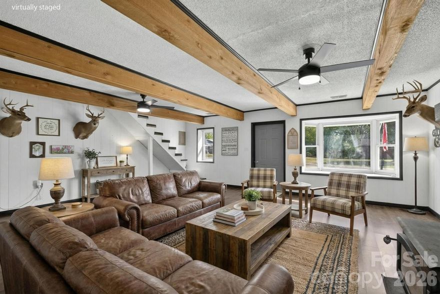 Remarkable property in the desirable Hudson/Sawmills area—perfect for the craftsman, hobbyist, or car enthusiast! The standout feature is the impressive two-bay garage, fully equipped with power and compressor hookup, offering endless possibilities for projects or storage. Adjacent to the garage, a finished outbuilding provides additional flexibility with a mini-split HVAC system, water heater, and sink—ideal for a workshop, studio, or bonus space.

The property offers abundant parking with a spacious driveway and two-car carport. Inside, you’ll appreciate the rustic charm, highlighted by a faux wood beam ceiling and cozy wood-burning stove. The kitchen features stylish black cabinetry, upgraded gold hardware, and warm butcher block countertops.

A main-level laundry closet is conveniently located in the third bedroom. Plus, don’t miss the nearly finished attic space—over 500 square feet with tall ceilings and permanent stairs—ready to be customized to fit your needs.

Virtual staging added to photos.