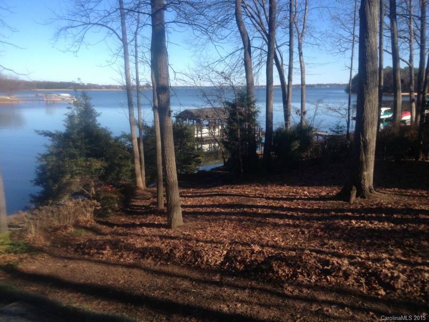 ¾ Acre treed lot.  4 miles-sunrise view.  Year round deep water.  Sheltered cove at Marker D-5, 2 Bedroom – 1 Bath cottage.  Extensive waterfront upgrades include pier w/gazebo and boat lift.  150 Foot shoreline.  Minutes from The Point and Trump National Golf Club.  No HOA/restrictions.  Natural gas at the street.  Irrigation system; nice landscaping waterside.  Low Iredell County taxes.  Existing well and septic.  Very buildable lot: gentle slope. Cottage being sold "AS-IS".