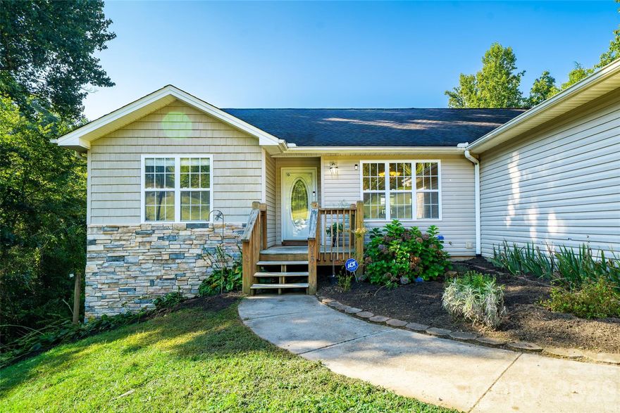 Discover privacy, acreage, and true potential in this Hendersonville home. Tucked at the end of a quiet gravel road, this 3-bedroom, 2-bath home sits on nearly 4 acres—a rare find for anyone searching for land in Hendersonville NC, room to build, or a possible second homesite.

Step inside to an inviting living room with soaring ceilings, open to the dining area and efficient galley-style kitchen—ideal for everyday living or entertaining. The spacious primary suite offers a custom walk-in closet with built-ins and a beautifully updated bath with a brand-new glass shower door.

The partially finished basement provides generous additional square footage with the opportunity to expand heated living area, create a second living space, or design your dream game room, office, or guest suite.

Enjoy the outdoors from the new deck overlooking your acreage—complete with raised garden beds and plenty of space to roam. With 3.61 acres of usable land, there is potential for an additional building site, making this property stand out for multigenerational living, investment, or future development.

An attached two-car garage adds convenience and extra storage.

If you're searching for a home in Hendersonville with privacy, land, expansion potential, and room to grow, this property combines it all—ready for your vision and life in the mountains.