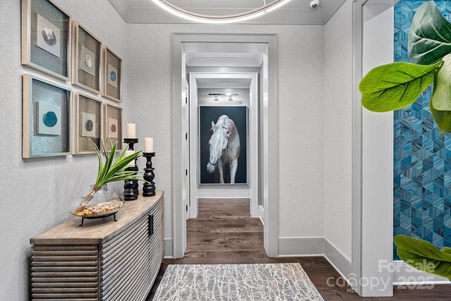 Welcome to Watermark, where your elevator opens into luxury, low maintenance living minutes from Lake Norman. Upgrades inc. linear gas fireplace, timeless kitchen w/double DWs, 48" Wolf double oven w/6 burners, griddle & pot filler. Bespoke cabinetry flanks kitchen & dining area, w/under counter SubZ ice maker, dual SubZ wine chillers w/refrigerator drawers & abundant storage. Living room flows to fully covered wrap around balcony w/water fountain, wall mounted TV & room for dining & lounging. Off the foyer is a library area w/hidden door for Control4 equip. Primary features covered balcony, soaking tub, boutique style closet, zero entry shower. 2 add'l en suite BRs & laundry room w/desk, powder BA, gallery style hallways accented with Phillip Jeffries wallpaper, art lights, Home Automation, Electric blinds & custom window treatments convey w/this stylish home. 2 deeded parking spaces w/EV charger. Amenities inc. Pickleball, gym, Clubhouse, putting green, pool, dog park, fire pit.