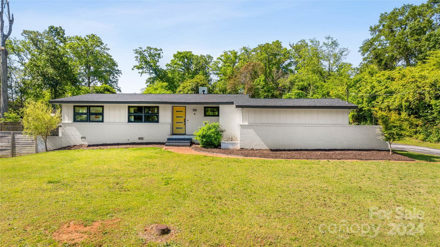 Mid century modern ranch home that is swoon-worthy has just come to market! The painted brick with wood accents, and stunning brand new Anderson windows make this home pop from the road! Clean lines from the top to the bottom, and the foyer offers terra cotta tile, wood wainscoting, and opens into a beautiful oversized living room with vaulted ceilings. Living room has wood beams and a three sided fireplace! Beautiful original hardwood floors, exposed beams, and updated lighting! The modernized kitchen has floating shelves, coffee bar area, stainless steel appliances, and breakfast bar!  The screened in rear porch overlooks your private backyard! Storage options in the crawl space and closets off the carport. Per seller, roof was installed 9/2023 and HVAC was installed in 2021. These, coupled with the new windows will provide you with years of worry free living!