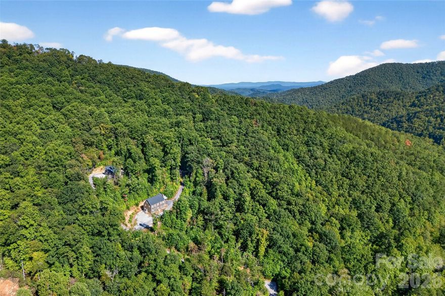 Surrounded by pristine national forest, this exceptional 6 bedroom, 6.5 bath mountain lodge offers year-round privacy, expansive living spaces, and panoramic mountain views. Located just 2 miles below the Blue Ridge Parkway, this property is an ideal family escape or high-performing short-term rental opportunity.
Inside, enjoy a spacious great room, large dining area, and a chef-inspired kitchen featuring two commercial refrigerators, double gas ovens- Bertazzoni appliances—perfect for hosting large groups. Each bedroom includes its own en-suite bathroom, providing comfort and privacy for guests. Option to be sold furnished.
Step outside to a covered entertainment deck, grilling area, and a mountain-view fire pit—the perfect setting for gatherings and unforgettable sunsets. With room to expand or add additional homes, this property offers remarkable potential for retreat operators or multi-family use.
Located just 45 minutes to Asheville and 10 minutes to Mount Mitchell Golf Club, this unique mountain haven blends convenience with unmatched natural beauty.
Ideal as: Family retreat, income-producing STR, group getaway, or investment property.
Ask Agent for financials. Cross posted - MLS for whole retreat 4342793 also MLS for 8032 Buck Creek.