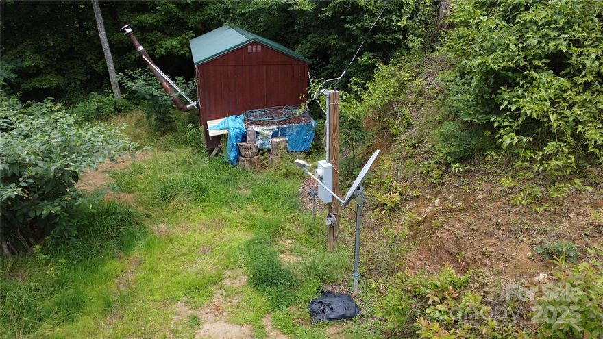 Escape to your own piece of paradise in the serene high elevations with this remarkable 0.79-acre lot boasting stunning south-facing views. Essential amenities including a outbuilding, well, septic system, and power connections are already in place on the homesite.  Just minutes from the Blue Ridge Parkway entrance and iconic spots like Waterrock Knob and Thunderstruck overlook, the location blends natural beauty with accessibility. Only 25 minutes from Waynesville and 45 minutes from Asheville, with easy access to downtown Cherokee and Maggie Valley, this property offers both seclusion and convenience. Newly cut gravel roads lead directly to the building site, enhancing accessibility and ensuring a smooth transition to your new mountain retreat. Whether you're planning a permanent residence or a vacation getaway, this corner lot in a private mountain community with minimal restrictions presents an unparalleled opportunity.  With all this lot has to offer, call today it won't last!