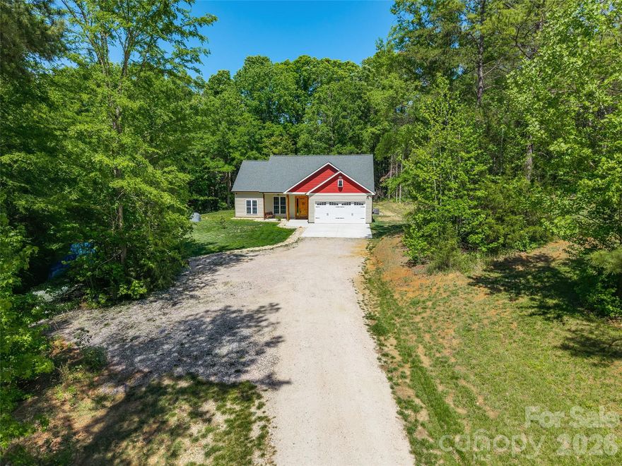 This beautifully maintained one-owner home, built in 2023, sits on 2.6 private acres and is thoughtfully set back off the road for added peace and seclusion. Surrounded by trees, the property offers a serene setting with both a welcoming front porch and a covered back patio, plus an additional uncovered area—perfect for enjoying the outdoors.

Inside, you’ll find a quality-built home with high-end finishes throughout, including insulated siding and energy-efficient windows that come with a warranty. The spacious interior features soaring ceilings and abundant character, highlighted by a stunning kitchen designed to impress. Enjoy beautiful custom cabinetry, a massive island ideal for gathering, and built-in decorative shelving.

This home combines modern construction, privacy, and stylish design—ready to welcome its next owner.
