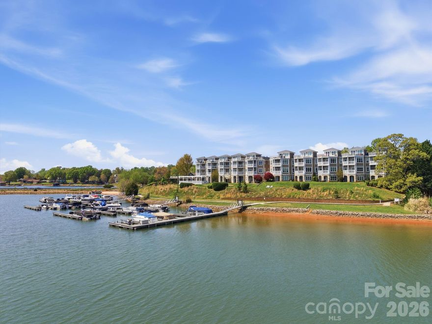 This rare 2-story penthouse condo on Lake Norman showcases spectacular waterfront views and is offered fully furnished for a true turnkey, move-in ready experience, ideal as a vacation retreat or investment opportunity. Thoughtfully appointed with hand-scraped walnut plank hardwood floors, tile in the baths, and carpeted bedrooms, the open floor plan is designed to maximize lake views from the kitchen, dining area, and living room, which opens to a covered balcony. The spacious primary suite features its own lake views, private balcony access, a walk-in closet, and a spa-like bath with garden tub and separate tiled shower with glass door. The well-equipped kitchen includes granite countertops, pantry, under-cabinet lighting, breakfast bar, and stainless appliances including a gas range, built-in microwave, dishwasher, and refrigerator with in-door ice and water. Additional highlights include 9-foot ceilings, ceiling fans with remotes in many rooms, built-ins in the living room, and a dual-sided gas log fireplace shared between the living area and primary suite. Two secondary bedrooms are located on the main level, including one with French doors, along with a full bath and a generously sized laundry room with washer and dryer included. A spiral staircase leads to a versatile loft with lake views, perfect for an office or flex space, with access to a private terrace that is ideal for sunbathing or relaxing. Decorated in a cohesive lake-inspired style, all furnishings convey. The building offers both stair and elevator access, and the front entry opens to a covered deck overlooking the community pool. Enjoy the convenience of two locally owned restaurants on the ground level, with easy access to shopping, I-77, medical facilities, and Mooresville.