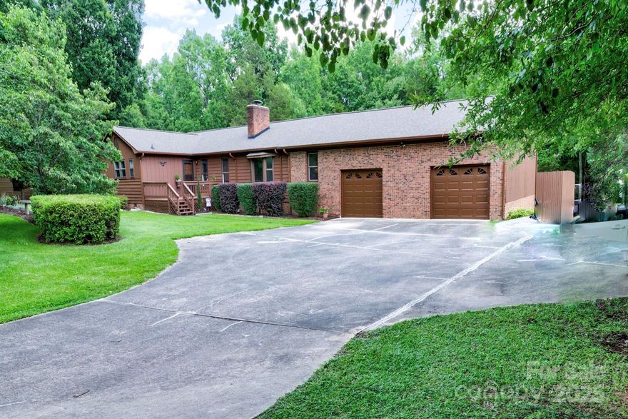 Sprawling ranch house on nearly 2 acres of land in quiet neighborhood in York!  The interior is quaint and homey with a wood burning fireplace and built-ins in the living room, and stunning exposed brick chimney and bay window in the formal dining room.  You will enjoy sipping your coffee every morning in the cozy sunroom overlooking the huge, private, fenced-in backyard.  Spacious layout affords lots of flexibility with additional rooms that can function as a den, office, or more!  Make it whatever you want!  Dream garage features built-in cedar closet.  Property includes 12 X 20 wired workshop with endless possibilities for expansion or conversion to additional living space. Back lot line extends past fence into wooded area. Exterior recently painted.  A real country gem conveniently located between York and Rock Hill--don't let this one slip away!