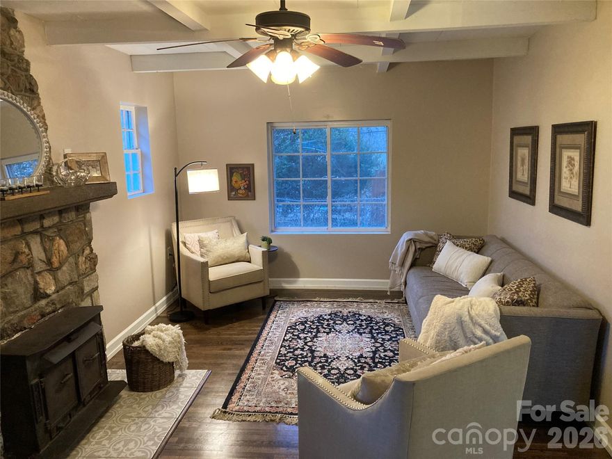 Location, charm, and versatility come together in this delightful Hendersonville cottage. Ideally situated just 15 minutes from Asheville Regional Airport and minutes to shopping, dining, and historic downtown Hendersonville, this inviting 2-bedroom, 2-bath home (1,125 sq ft) offers both convenience and timeless character.

Originally built in 1940, the home retains its classic appeal with newly refinished hardwood floors, a distinctive coffered ceiling, 5 yr old roof and fresh paint throughout. The welcoming living room is centered around a beautiful stone fireplace with a cozy wood-burning stove, creating a warm and inviting gathering space.

The updated kitchen blends vintage charm with modern functionality, featuring granite countertops, stainless steel appliances, and ample workspace for everyday living and entertaining.

Thoughtfully designed for comfort and flexibility, each bedroom connects directly to its own full bath, making the layout ideal for guest privacy, shared living arrangements, or a comfortable primary residence. Whether you’re searching for a first home, downsizing opportunity, or investment property, this cottage offers exceptional adaptability.

Outside, the property provides a spacious yard with partial fencing, perfect for gardening, pets, or outdoor relaxation. A detached garage and lower-level workshop/garden space offer additional flexibility for hobbies, storage, or creative projects. The rear porch room can easily serve as additional seasonal living space with the addition of a small heater (not included in square footage), while the large attic provides abundant storage.

Located on a quiet dead-end street, the setting offers peace and privacy without sacrificing convenience to nearby Ingles, restaurants, and the vibrant shops and events of downtown Hendersonville.

Move-in ready, full of character, and perfectly located—this charming cottage is ready to welcome its next chapter.

Seller is a licensed NC Broker/Realtor.