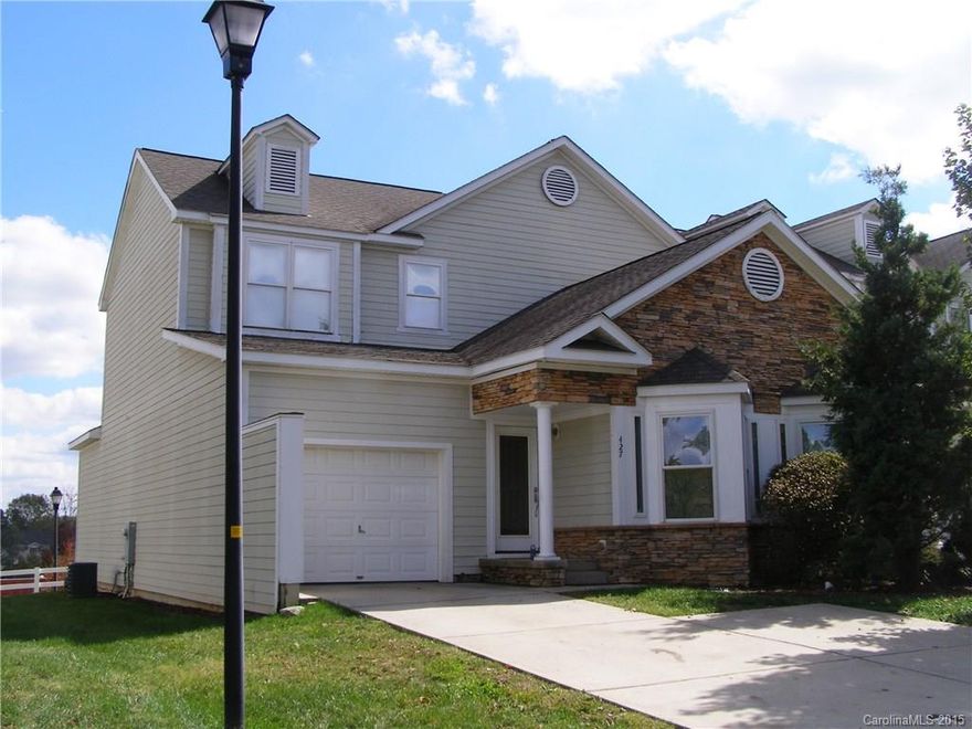 RARE FIND IN FORT MILL - END UNIT TOWNHOME WITH 4 BEDROOMS + 1 CAR GARAGE! Crown molding throughout. Hardwoods in entry, Kitchen & Dining. Main level Master accented by tray ceiling, has double closets  & deck access. Private bath offers dual sink vanity, tile flooring & large shower. Bright Living Rm also opens to deck. Half Bath has pedestal sink, large laundry w/utility sink. Three good sized secondary bedrooms + full bath w/ tile flooring up. Great curb appeal with stone accents on exterior.