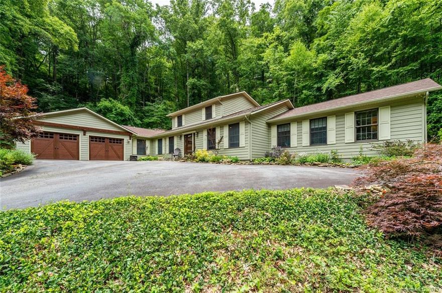 Gorgeous north Asheville home without city taxes.  Updated with loads of light.  Newer roof, sealed crawlspace and french drains installed around back perimeter. New skylights in family room, 2 baths have been updated.  Kitchen updated.  Shows like a newer home.  Hardwood flooring in living areas.  Large master suite 14x24.Bright sunroom off of master suite. Everything you need on one level with exception of secondary bedrooms. Idyllic stream on property.  Plenty of storage with oversize garage.