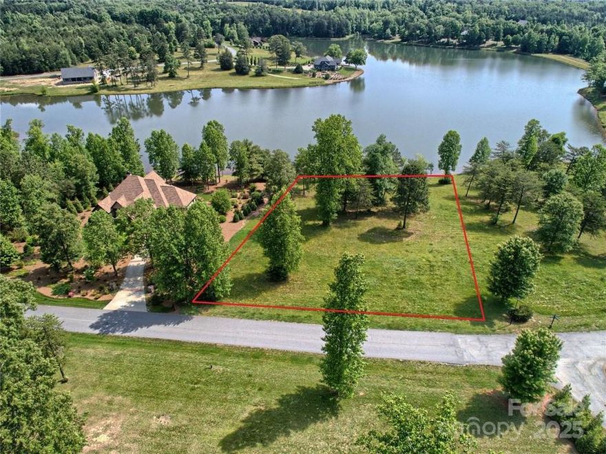 WATERFRONT—DERBYSHIRE (Foothills of Tryon/Columbus, NC): A rare premium lakefront homesite in an equestrian-oriented, gated community—where elegance, access, and outdoor living meet. One of the last great true-waterfront opportunities on Derbyshire’s private ~33-acre swimmable/fishable lake, this lot pairs beautiful topography + view corridors with a flexible builder program so you can craft exactly what you want.
***Please see the other MLS Listing for the Land + Home Package Option: Buy the lot or have the seller/builder deliver your high-end custom home. Start with a primary-on-main or single-level plan, add a walkout lower level for guest suites/entertaining, and step straight to a gunite pool terrace and the water for kayaking/paddleboarding. Expect thoughtful architecture that orients to the lake, Superior Walls foundation, whole-home audio, and luxe, seamless indoor–outdoor living. Choose the featured plan or fully customize from the premium spec sheet—qualified buyers may tailor finishes prior to construction start.
Derbyshire blends refined country living with true equestrian DNA: community warm-up rings, barn/stables, arena, individual paddocks, established pastures, ~8 miles of internal walking/riding trails across 260+ acres, and connectivity to regional trail systems (CETA/FETA). Morning hacks, sunset lake strolls, coffee on the dock—this is effortless Foothills living.
Location, Location, & Access: All-paved, easy-in/easy-out to I-26 (Landrum exit); minutes to dining/services in Tryon, Landrum, Columbus and an easy drive to the world-renowned Tryon International Equestrian Center (TIEC) for shows, trainers, and boarding. Traveling? You’re roughly ~45–60 minutes (traffic dependent) to GSP or AVL, and about an hour (+/-) to CLT—rare international access while keeping your lake-and-horse lifestyle intact.
True WATERFRONT inside a gated, equestrian-minded community with quick highway access is nearly impossible to replicate. The setting, shoreline, and build flexibility here create a best-of-both-worlds opportunity—buy now, build now (or later), and tailor the home you’ve been sketching in your head.
In this Gated community an appointment is required. A licensed real estate agent must accompany buyers. (*The builder is happy to walk the property, review elevations, specs, timelines, and allowance packages. Other home styles available upon request. Bring your vision; your custom Derbyshire retreat awaits.)