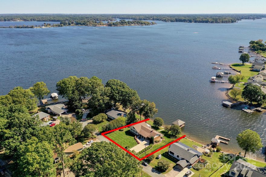 Experience Lake Norman living with sweeping water views from this waterfront ranch with a finished walk-out basement! Set in a peaceful lakeside setting with easy access to the water, this home offers a rare opportunity to enjoy the lake now while envisioning future updates tailored to your needs. 

The great room features soaring ceilings, exposed beams, and a floor-to-ceiling brick fireplace that anchors the space with warmth and character. A set of French doors opens to the newly remodeled deck, inviting natural light and drawing your eye straight to the lake—perfect for enjoying the view from inside or out.

The open-concept layout connects the great room, dining area, and kitchen, creating a functional flow for everyday living and entertaining. The kitchen offers knotty pine cabinetry, granite countertops, and ample workspace, providing a solid foundation for future customization while enjoying beautiful lake views.

The main-level primary suite is positioned to capture the water view and opens directly to a sunroom—an ideal spot for morning coffee or a quiet place to relax. The updated bath adds a touch of modern comfort. A private staircase from the suite leads to two additional flexible rooms is perfect for a home office, studio, or exercise space.

Two additional bedrooms and a full bath on the main level offer comfortable accommodations for family or guests.

The finished lower level expands the home’s versatility with a second kitchen, spacious living area, flex room, and full bath. With its own entrance and access to the patio and yard, this space is well-suited for guests, extended living, or multi-generational use.

Outdoor living centers around the deck and patio—ideal for entertaining, dining, or simply taking in the expansive lake views! Easy access to the water and a private dock complete the lake lifestyle, offering opportunities for boating, swimming, fishing, or enjoying peaceful moments by the shore.

With its panoramic views, flexible layout, and exceptional waterfront setting, this property presents a compelling opportunity to enjoy the true Lake Norman lifestyle!