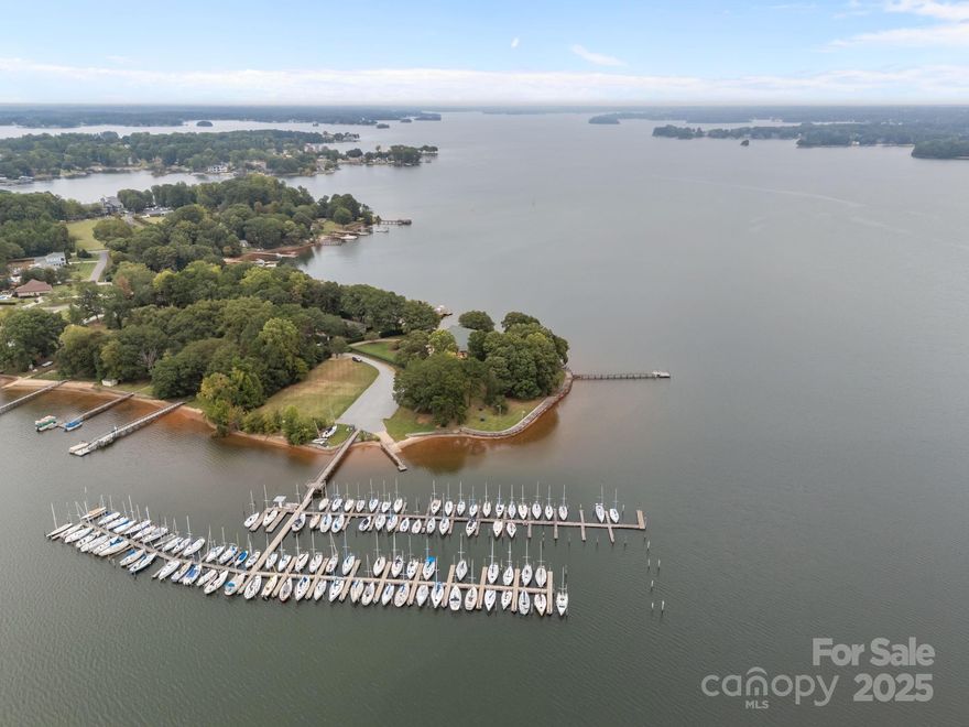 PARADISE FOUND! Welcome to 1887 Yacht Club Drive. This 2.8 acre point lot includes a thousand feet of  shimmering Lake Norman shoreline. Resort style living at its best. This estate is simply the crown jewel of Lake Norman. Begin your mornings with sunrises over the lake and end your evenings with spectacular sunsets watching sailboats finding their way home. This one of a kind estate is being offered for the first time ever. The compound includes a main home, three attached townhomes and a spacious sailing club property with over one hundred and twenty boat slips. The main home includes four bedrooms and three and a half bathrooms. The three townhomes include a total of seven additional bedrooms and four full baths The sailing club structure offers a meeting room, two bedrooms and three full baths. This distinctive property allows for both connection and privacy for friends and guests. Perfect setting for a corporate retreat or multigenerational living.  The  main home boasts stunning architecture where luxury and high functioning comfort blend seamlessly. Highlights include an open modern floorplan with two-story stone fireplace, soaring wood ceilings, and a spacious sitting room with one hundred eighty degree Lake Norman views. The rooftop terrace offers a panoramic three hundred sixty degree view of the shimmering waters of Lake Norman. The spacious primary suite offers privacy, lake views, a hidden safe room, and luxurious bath with dual closets. baths, and a loft. A rare boardwalk surrounds the waterfront edges of the property. Lush landscaping and  expansive patios gives this enclave show stopping outdoor spaces.  Simply the most serene and beautiful property on Lake Norman. Please do not miss this once in a lifetime opportunity.  Investors must walk the property to note the endless possibilities that this property offers.  This property is being sold with adjacent parcel 1890 Yacht Club Road.