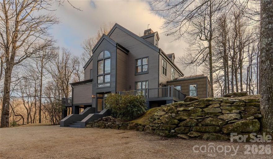 Welcome to Hodge Podge Lodge, a true family mountain retreat set privately among the trees in The Cliffs Valley. Designed as a refined yet relaxed “mountain camp,” this Modern Mountain Craftsman blends timeless architecture with warm, livable design on nearly three acres with mountain views, a tranquil pond, and a peaceful wooded backdrop.

Steep gabled rooflines, natural materials, and earth-toned siding with charcoal accents anchor the home seamlessly into its setting. Inside, soaring ceilings and an open, airy layout define the main living spaces, centered around a dramatic three-story stone fireplace that serves as both a visual focal point and a natural gathering place. The living room flows effortlessly into the chef’s kitchen and dining area, framed by expansive doors that open outdoors and capture beautiful mountain views, creating an ideal indoor-outdoor connection for everyday living and entertaining.

Rich wood floors, custom built-ins, and thoughtfully detailed ceilings add warmth and texture throughout. Just beyond the main kitchen, a fully equipped back kitchen and butler’s pantry enhances functionality with additional oven, refrigeration, and prep space, allowing the home to comfortably host gatherings of any size while remaining connected to the heart of the home.

The primary suite is a true sanctuary, featuring vaulted ceilings with exposed beams, a reclaimed wood accent wall, and a beautifully updated bath with soaking tub and walk-in shower. Large windows throughout the home invite natural light and rolling mountain views, reinforcing a strong connection to the surrounding landscape.

Outdoor living unfolds across multiple levels, from the screened porch and wraparound decks with mountain views across a "gangway" to a charming treehouse. A conservatory-style sunroom offers a cozy perch among the trees by day and a magical setting for stargazing by night.

The reimagined third floor features a custom lodge-style bunk room, fireplace, and flexible recreation space ideal for guests, grandchildren, or multi-purpose living. With three bedrooms, four bathrooms, and flex rooms and studies, the home offers excellent versatility and comfortably sleeps up to eighteen.

The expansive basement level offers plenty of space for impressive man cave, workshop and parking.

Recent improvements include a remodeled kitchen and primary suite, refreshed third floor, new bedroom flooring, remodeled wet bar, custom fireplace built-ins, wood-accent ceiling details, fresh interior and exterior paint, new HVAC systems, and new kitchen appliances.

Located within one of the Upstate’s most sought-after gated mountain communities, residents enjoy optional membership with access to all seven Cliffs clubs and convenient proximity to Travelers Rest, Greenville, Hendersonville, and Asheville.

Cliffs Valley homes with similar views sell for $400-500/Square Foot. Hodge Podge Lodge is priced at $312/foot to account for it's whimsical features. 

This is mountain living designed for gathering, retreating, and making memories that last.