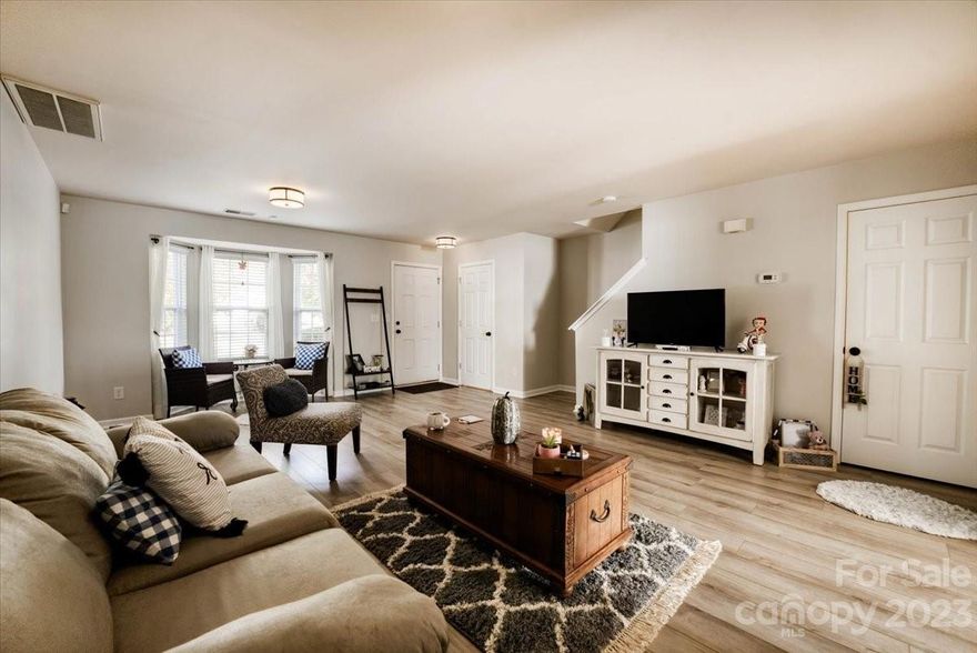 Take in the view as you are welcomed into a spacious living room area upgraded with fresh paint and absolutely breath taking luxury vinyl flooring that is continuous throughout the main level. Relax in the sitting area by the  bay window for views of the tree lined streets with sidewalks. This townhome boasts of a lovely kitchen with a large island laid with granite. Wainscot trim along the entrance to the kitchen and dining area bringing elegance to the space. Large walk in pantry. Take a peek through the French doors to notice possibly the largest backyard for a townhouse that you've ever seen - Fully fenced! Upstairs, the plush carpet springs comfortably under your feet with each step. The primary bedroom is warm and inviting with a walk in closet and on suite that features double sinks, a soaking tub and an oversized shower. Ample storage. All new toilets. 2022 Water Heater. Condensor with new parts. Also, the community pool is being renovated in preparation for summer!