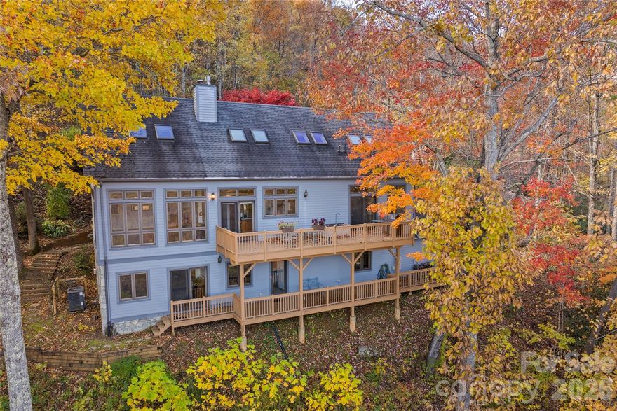 Welcome to Laurel Ridge — A Sanctuary Above the Clouds.

Tucked gracefully into the emerald folds of the Blue Ridge Mountains, this exquisite custom-built post and beam residence invites you to experience life at a higher elevation—both literally and spiritually. Here in beautiful Laurel Ridge, just minutes from the vibrant town of Black Mountain, nature and craftsmanship come together in perfect harmony.

From the moment you arrive, the home reveals itself as a masterpiece of mountain architecture—warm wood beams, thoughtful design, and walls of glass framing breathtaking long-range views that stretch endlessly across the horizon. These are views to savor in every season, from the soft greens of spring to the fiery palette of autumn, all visible from expansive decks designed for lingering mornings and starlit evenings.

At the heart of the home, a Swedish-style Tulikivi fireplace stands as both a sculptural centerpiece and a marvel of efficiency. Ingeniously designed to heat the entire home with minimal wood, it offers a gentle, steady warmth that feels as timeless as the mountains themselves.

With four bedrooms and three and a half baths, this residence offers space for family and friends to gather in comfort and style. Every detail speaks of intention—custom craftsmanship, soaring ceilings, and a sense of serenity that permeates every room. The home is connected to the community water system yet also boasts its own private well, while a 1,000-gallon propane tank fuels the stove, dryer, water heater, and a cozy lower-level fireplace—ensuring both independence and convenience.

Outdoors, a world of mountain living awaits. Beautiful decks on the main and lower level invite effortless entertaining against a backdrop of rolling ridgelines and shifting skies.

This is more than a home—it’s a retreat. A place where morning mist gives way to sunlit vistas, and where the crackle of a single log in the fireplace becomes the soundtrack to your mountain life.

Welcome to Laurel Ridge. Welcome home.