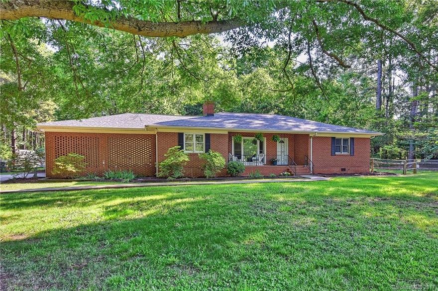 Full brick ranch located on wooded 0.82 acre lot! Features include: fresh paint throughout, 3BR/3BA, 2 master bedrooms with skylights, den with fireplace, spacious kitchen with breakfast area,  one car garage, screened porch, rocking chair front porch, fenced yard, large deck, storage building and huge patio with basketball goal. Well with working pump house that could be used to water lawn.  HWA home warranty!