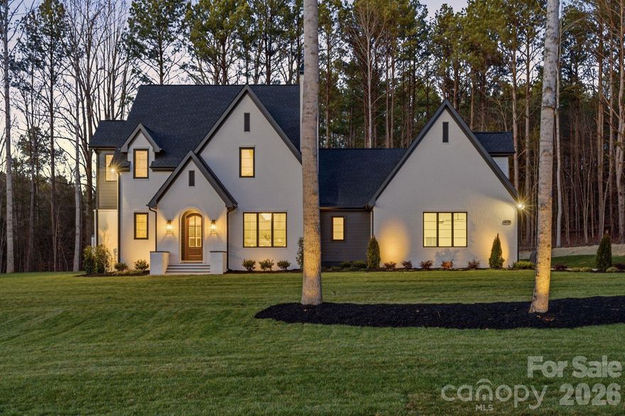 Nestled within an exclusive 36-homesite community where every residence enjoys over an acre of land, this extraordinary home represents a level of quality and craftsmanship rarely found in the Clover market. From the moment you arrive, the impeccable manicured grounds — complete with full sod and irrigation — set the tone for the exceptional experience that awaits.

Step inside and immediately feel the difference. Every detail, from the curated finishes to the refined architectural elements, reflects a commitment to luxury throughout. Bathed in natural light, the home is complemented by a stunning high-end lighting package that enhances each space with warmth and sophistication.

The chef’s kitchen is both beautiful and functional, featuring extensive custom cabinetry, a custom hood, elegant marble countertops, high-end appliances, a farmhouse sink, and thoughtful storage designed for everyday living and entertaining alike.

Gather in the inviting living room beside the gas fireplace with stone surround, or enjoy the charm and flexibility of the second fireplace in the parlor or dining room — tailored to suit your lifestyle.

The primary suite is a true retreat, offering a spa-like bath complete with a luxurious custom arched walk-in shower, freestanding soaking tub, and bespoke cabinetry. Subtle touches of wallpaper and carefully selected paint colors add character and depth throughout the home.

Designed with versatility in mind, the home features two distinct upper living areas. Above the main residence, you’ll find a loft, three bedrooms, and two full baths. Above the garage — just off the kitchen and drop zone — a spacious flex or bonus room with full bath offers endless possibilities for a guest suite, media room, office, or private retreat.

Out back, unwind or entertain on the covered patio, where privacy and peaceful surroundings create the perfect setting for quiet evenings or gatherings with friends.  Home ready for your pool

Enjoy the serenity of a private, country-like setting while remaining just minutes from coffee shops, dining, shopping, and everyday conveniences — and only 17 miles from Charlotte Douglas International Airport.

This is more than a home — it’s a statement of craftsmanship, comfort, and timeless luxury.