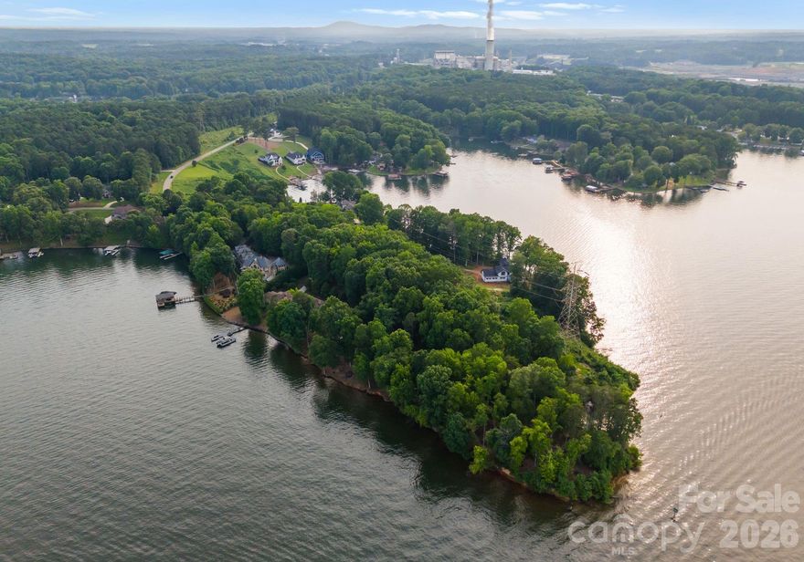 Presenting a rare opportunity to own a magnificent 4-acre waterfront estate on the main channel of Lake Norman. With an impressive 1,200 feet of shoreline, this Mediterranean-style residence offers unparalleled privacy and panoramic water views. The meticulously landscaped grounds feature a luxurious spa pool with a hot tub, a private sandy beach, a premium floating dock, and a serene Japanese garden complete with a waterfall—creating a resort-like oasis perfect for both grand-scale entertaining and tranquil escapes or yoga retreat.
Inside, the home's grandeur is immediately apparent with a soaring two-story stone fireplace that serves as the focal point of the sun-drenched great room. The open-concept floor plan is thoughtfully designed for modern living, with arched entries and expansive windows framing the stunning lake vistas. A chef's kitchen, equipped with granite countertops,  stainless steel appliances, and a butler's pantry, flows seamlessly into the dining and living areas.
The main level primary suite is a true retreat, with lavish bathroom with both indoor and outdoor showers, a jetted tub, and dual vanities. The upper level offers a versatile loft space, ideal for a playroom or billiards room, along with two generously sized bedrooms, each with its own terrace overlooking the lake and pool. The fully finished walk-out basement provides additional living and entertaining space, including a media room, recreation area, and two private guest suites.
This exceptional property, complete with a distinctive bell tower and a three-car garage, is conveniently located just minutes from shopping, dining, and major highways for easy airport access. Experience the pinnacle of luxury lakefront living in this one-of-a-kind Lake Norman estate