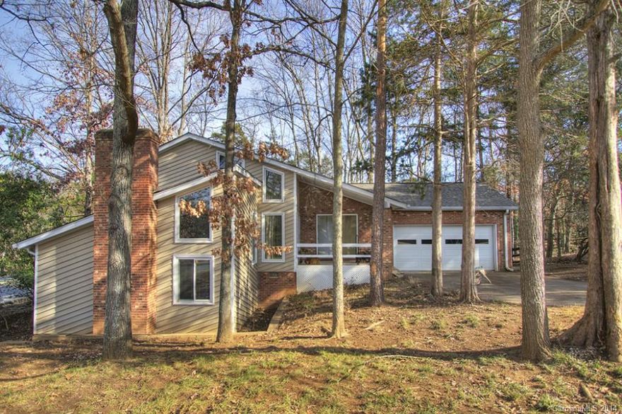 Updated contemporary living with vaulted ceilings in living room, tile floors, large two-level deck overlooking fenced backyard and ample two-car garage.