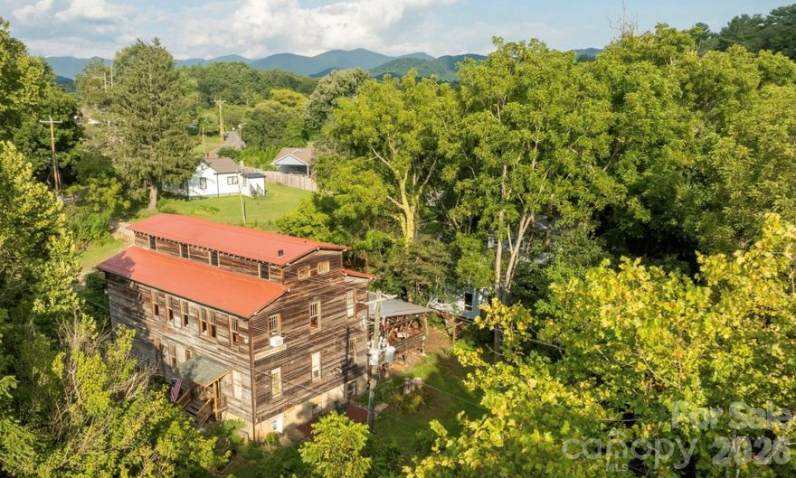 Historic Weaverville Milling Company.  Circa 1914 ...Ready for additional restoration. Would make Incredible Custom Home or Club with renovations! Rare Opportunity.....150+ year old Grist Mill / former 150 seat Restaurant includes 3 bedroom House and 1 bedroom Cottage, on 5.25 acres, fronts 1,000 ft. on Reems Creek waterway. Located in the County & only 10 min. to Downtown Asheville.  Ideal for Private Club, Event Space, Custom Home w needed updates or Restaurant.... The Mill is over 7,000 sq.ft. + 1,400 sq ft  covered patio. The Old Mill building is beautiful with strong local history. Old house (1940s) remodeled w 3 bed /2 bath approx, rear deck, large unfinished lower level daylight basement. Old Cottage remodeled w 1 bed and 1 bath , kitchenette approx. 600 SQ Ft with 300 sq ft rear deck.    Zoning allows short term rental and mixed use commercial.   1 Old Mill lane lot zoned EMP, 9 Old Mill lane zoned R-3. Not in Weaverville City limits. Property has City Water,  Sewer & Natural Gas.  Structures not impacted during Helene. Property has incredible private sanctuary along the waterway. Some photos enhanced with AI to show update potential and residential potential.