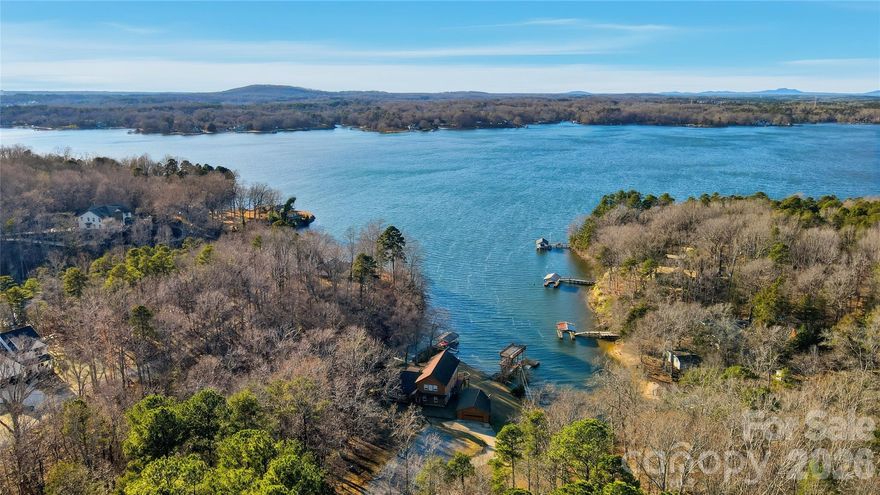 Discover the perfect blend of peace and play at this charming Lake Wylie retreat.  Featuring a gently sloping lot in a quiet, protected cove with long range main channel views. Surrounded by mature hardwoods, the property offers privacy, natural beauty, and tons of space for outdoor enjoyment. Spend your days boating, fishing, or swimming from your covered dock with lift, then unwind on the sundeck while taking in tranquil lake views. Whether you’re seeking a serene weekend getaway or comfortable full-time living, this waterfront home delivers the best of lakeside living and is ready for your personal touches.  Inside the home discover a spacious eat-in kitchen with stainless steel appliances, center island, pantry, and wet bar.  A flex room(perfect for a home office),  2 bedrooms, 2 baths, dining room, and amazing 2 story great room with stunning lake vistas complete the main floor.  The upper-level primary suite offers breathtaking lake views, dual vanities, a walk-in shower, jetted tub, and generous storage. The lower level provides a large recreation room, perfect for entertaining family and friends. Multiple decks create ideal spaces for grilling, hosting, or simply relaxing and enjoying the scenery. With its unbeatable value, versatile living spaces, and exceptional waterfront setting, this Lake Wylie gem offers endless potential.  Great location- Palisades Country club nearby with golf, social, pool, and tennis memberships available.