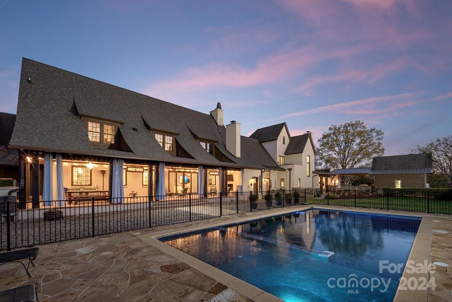 Nestled on 15.1 acres near Lake Norman and Charlotte Motor Speedway, this 11,421 sqft estate offers a Davidson address with lower Iredell County taxes. Featuring Trinity Hall and Hiefield House, connected by a Grand Hall, the estate includes 8 bedrooms, gourmet kitchens with Wolfe appliances, and ADA-compliant features. Enjoy hand-hewn beams, Tennessee stone fireplaces, expansive verandas, and stunning woodland views. Modern comforts include a high-tech security system and hotel-sized septic. Experience unparalleled luxury in this exquisite estate.