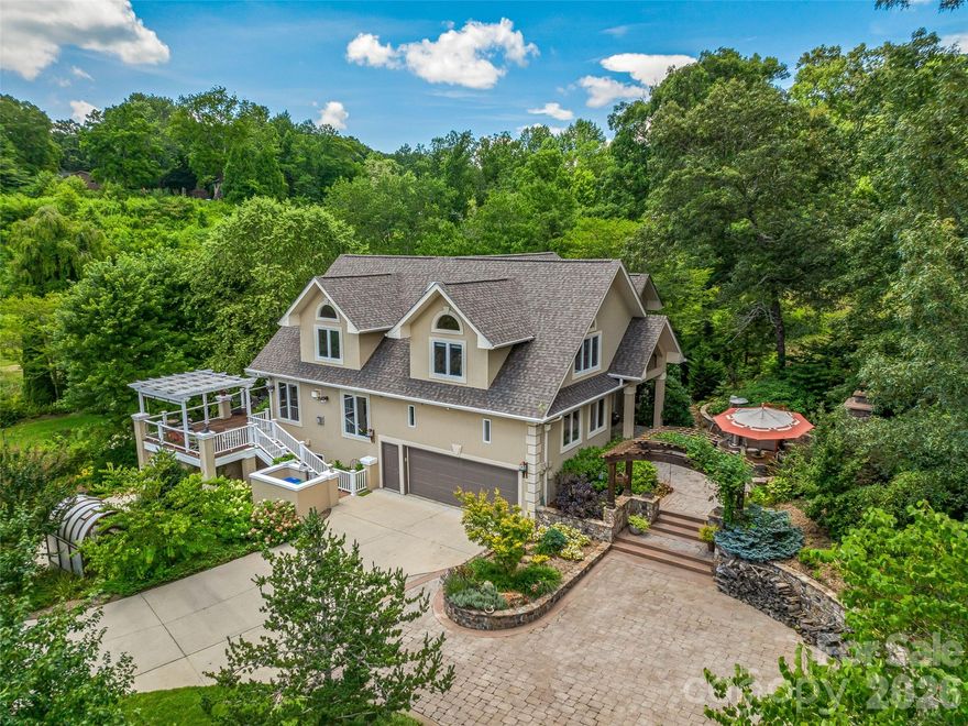 Nestled on .92 acres of horticultural splendor within the gated community of Keswick Hills, this stunning custom home is a rare marriage of architectural elegance and botanical artistry. While the home itself is a masterpiece, the grounds are a living legacy—meticulously curated by a Master Gardener over decades of thoughtful design and nurturing care. The Grounds: A Master Gardener’s Vision, the exterior of this property transcends traditional landscaping, offering a private park-like setting that must be seen to be believed: Decades of Curation: Mature, specimen trees and lush, layered perennials create a symphony of year-round color and privacy. Artful Design: Meandering paths lead to tranquil garden "rooms," offering serene spaces for reflection or grand outdoor entertaining. Nature & Serenity: The established gardens provide a lush, green buffer making the .92-acre lot feel like a vast, secluded retreat. The Residence, Crafted Elegance: Inside, the home is bathed in natural light and defined by exquisite details. Artisan Touches: Handcrafted stained glass windows by local artisans infuse the home with warmth and a unique mountain character. Chef’s Dream: A gourmet kitchen serves as the heart of the open living area, seamlessly connecting to multiple indoor and outdoor entertaining spaces. Spacious Layout: Boasting 4 bedrooms and 3.5 baths, the floor plan is designed for both refined comfort and practical luxury, complete with two attached garages and abundant storage. Location: The Best of Both Worlds, Keswick Hills offers an unparalleled lifestyle, balancing high-country peace with city convenience: Educational Hub: Ideally located near a premier selection of public, charter, and independent schools, providing families with exceptional choices. Close to the Action: Enjoy being just minutes from Asheville’s top-tier shopping, world-class dining, and vibrant arts scene. Urban Proximity: Experience true mountain living without the commute—you are only 15 minutes from the heart of Downtown Asheville. This is mountain living at its most refined—a home where every detail, from the artisan glass to the master-tended soil, reflects a commitment to quality and beauty.