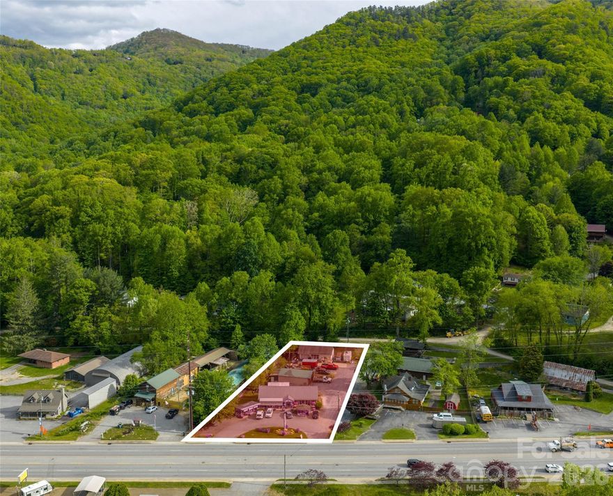 This exceptional 0.75-acre prime commercial property occupies a high-visibility location on a bustling five-lane thoroughfare leading directly into the heart of Maggie Valley, North Carolina. Boasting over 140 feet of prime road frontage, the site enjoys exceptional exposure and daily traffic counts that deliver constant customer flow. Positioned directly across from the prestigious Maggie Valley Country Club entrance, the property benefits from steady patronage by club members, golfers, tourists, and local residents year-round. The site features three buildings with establishe