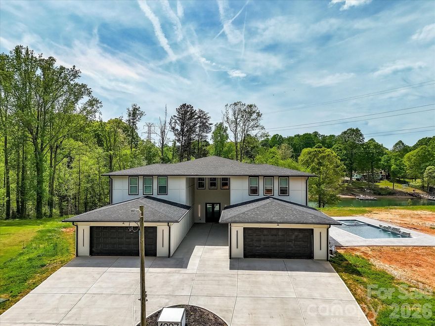 Stunning modern lakefront home perfectly positioned on a peaceful cove with 1100' of shoreline on Lake Norman, offering expansive water views and a large private lot. This thoughtfully designed residence features bright, open-concept living spaces with soaring ceilings, a statement fireplace, and seamless flow into a sleek, oversized kitchen with a large island—ideal for entertaining. The home includes multiple spacious bedrooms, many with private ensuites, including a luxurious primary suite with a spa-like bath, freestanding soaking tub, walk-in shower, and a custom closet with built-ins and in-closet laundry. Additional highlights include a stylish dining area, dedicated office, flex spaces, a music room, and a private theater. Enjoy outdoor living year-round with a covered patio, expansive balcony with water views, and a large backyard leading to the waterfront. The unfinished basement offers endless potential for customization, while the outdoor pool and spa area is ready for your dream backyard retreat. This exceptional property combines modern design, functional living, and a prime lakefront setting. This home is a true MUST SEE! **Short term rentals are allowed**