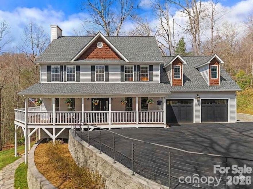 SELLER IS OFFERING A $4000 ALLOWANCE TO CONVERT THE FINISHED GARAGE SPACE BACK INTO A FUNCTIONAL GARAGE THAT WOULD REMAIN CLIMATE CONTROLLED. Set within a completely private, wooded setting in a desirable neighborhood, this beautiful 2-story home was designed to live with both intention and flexibility. A full second living quarters with a separate entrance, featuring its own kitchen, living room, and bedroom suite, offers a seamless solution for multi-generational living, extended stays, or income potential.

Spanning over 4,600 square feet, the home welcomes you with a charming wraparound covered porch that extends to the back, creating multiple places to relax and take in the surroundings, including winter mountain views. Inside, oversized windows bring in an abundance of natural light, highlighting a well-balanced layout with defined living areas, hardwood floors, and a stone fireplace that anchors the living room. 

The kitchen has been fully renovated from top to bottom with upscale finishes, generous workspace, and an easy connection to the dining area and outdoor living. A full interior paint refresh and upgraded entry with an oversized glass door add to the clean, cohesive feel throughout.

The main-level garage has been thoughtfully converted into a large finished space, well-suited for a home gym, office, or recreation room. Upstairs, a bonus room adds even more flexibility for how the home lives day to day.

The primary suite offers a spacious layout with a beautifully updated ensuite bath, while additional bedrooms provide comfortable accommodations for family or guests.

Recent improvements also include a brand-new roof installed in 2026, an EV charging station, fiber internet, expanded parking, septic expansion, and professionally designed hardscaping with added exterior lighting.

Enjoy quick access to the Blue Ridge Parkway for endless outdoor adventure, all while being just a short drive to Fairview and the energy of downtown Asheville, where local dining, shopping, and culture come together. RARE OPPORTUNITY TO ASSUME A 2.25% VA FIXED-RATE MORTGAGE OF APPROXIMATELY $380,000 (NON-VETERANS WELCOME), OFFERING SIGNIFICANT SAVINGS COMPARED TO CURRENT MARKET RATES. BUYERS MAY COVER THE DIFFERENCE WITH CASH OR SECONDARY FINANCING, RESULTING IN A LOWER BLENDED RATE. SUBJECT TO LENDER APPROVAL. Garage doors shown in photos are digitally added for illustrative purposes only. The doors do not currently exist.