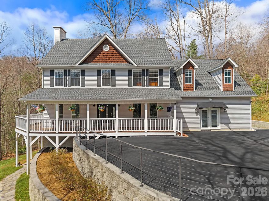 Set within a completely private, wooded setting in a desirable neighborhood, this beautiful 2-story home was designed to live with both intention and flexibility. A full second living quarters with a separate entrance, featuring its own kitchen, living room, and bedroom suite, offers a seamless solution for multi-generational living, extended stays, or income potential.

Spanning over 4,600 square feet, the home welcomes you with a charming wraparound covered porch that extends to the back, creating multiple places to relax and take in the surroundings, including winter mountain views. Inside, oversized windows bring in an abundance of natural light, highlighting a well-balanced layout with defined living areas, hardwood floors, and a stone fireplace that anchors the living room. 

The kitchen has been fully renovated from top to bottom with upscale finishes, generous workspace, and an easy connection to the dining area and outdoor living. A full interior paint refresh and upgraded entry with an oversized glass door add to the clean, cohesive feel throughout.

The main-level garage has been thoughtfully converted into a large finished space, well-suited for a home gym, office, or recreation room. Upstairs, a bonus room adds even more flexibility for how the home lives day to day.

The primary suite offers a spacious layout with a beautifully updated ensuite bath, while additional bedrooms provide comfortable accommodations for family or guests.

Recent improvements also include a brand-new roof installed in 2026, an EV charging station, fiber internet, expanded parking, septic expansion, and professionally designed hardscaping with added exterior lighting.

Enjoy quick access to the Blue Ridge Parkway for endless outdoor adventure, all while being just a short drive to Fairview and the energy of downtown Asheville, where local dining, shopping, and culture come together.