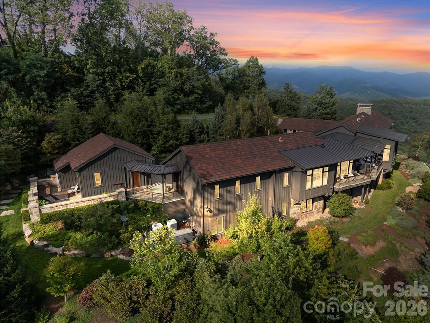 A Private Mountain Estate Above Asheville | A Masterpiece of Light, Landscape, and Luxury

Perched at an elevation of 3,600 feet, this extraordinary mountain estate captures sweeping sunrise-to-sunset, long-range views over the city of Asheville and the surrounding Blue Ridge Mountains. It is atop one of the most commanding vantage points in Asheville.  From the first light of day rising over Mount Mitchell to the final glow of evening settling over twinkling city lights, every moment here is framed by nature’s grandeur.  This estate has a sweeping 300 degree panoramic view spanning layered Blue Ridge horizons to the distant glow of the city below.  It was designed for those who seek privacy, scale and distinction.  This is a true trophy residence--rarely available and nearly impossible to replicate.  
Wake to fireside coffee on the eastern covered terrace as the morning sun spills across layered mountain ridgelines. As dusk arrives, gather with friends and family to toast unforgettable sunsets, where sky and landscape dissolve into a living canvas of color and light.
Designed for casually elegant living, this residence is a rare collaboration between architect Jim Samsel and Morgan-Keefe Builders. The result is a one-of-a-kind home where refined craftsmanship meets modern mountain sophistication. Antique warehouse beams, thoughtfully sourced, lend warmth and character to the clean architectural lines, while expansive French doors throughout dissolve the boundary between indoor and outdoor living.
The home is appointed with the finest finishes and systems, including high-end appliances, advanced mechanical infrastructure, and four generous garages—each element curated to support both luxury and performance.
Beyond the interiors, the grounds unfold into a private botanical sanctuary. Over 6,000 curated plantings envelop the estate, anchored by an exceptional collection of Japanese maples representing a diverse range of species, textures, and seasonal color. Blooming florals and layered landscaping create a dynamic display that evolves throughout the year, offering continuous beauty across all four seasons. The setting evokes the rare feeling of a tropical rainforest nestled within the mountains—lush, immersive, and profoundly serene.
Outdoor living is elevated to an art form, with multiple terraces, gathering spaces, and two outdoor fireplaces designed for year-round enjoyment. Complementing the estate are thoughtfully designed outbuildings that transform wellness into an experience—ideal for fitness, recovery, and cold plunge immersion.
The spa sanctuary is nothing short of extraordinary. A custom-designed sauna features a full viewing wall framing unobstructed vistas of Mount Mitchell, allowing you to unwind while immersed in the natural landscape. The adjoining spa is crowned with a Rolls-Royce-inspired starlight ceiling, meticulously crafted to mirror the night sky beyond—creating a tranquil, immersive retreat unlike any other.
Located within a private gated community just eight minutes from downtown Asheville, the property offers effortless access to exceptional schools, leading healthcare, outdoor recreation, and a vibrant culinary and arts scene.
This is more than a home—it is an experience of place, a sanctuary of design, and an invitation to live fully immersed in beauty, comfort, and timeless mountain elegance.