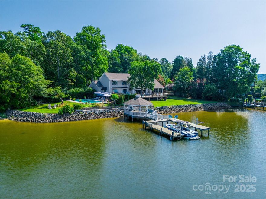 Welcome to a rare offering of unparalleled beauty and sophistication—a lakefront estate boasting 250 feet of pristine shoreline and sweeping, panoramic water views. Nestled in an exclusive gated community.Expansive windows and thoughtfully designed living spaces capture the ever-changing light over the water, offering breathtaking vistas from nearly every room. Step inside to discover soaring ceilings, rich hardwood floors, and bespoke finishes throughout. The heart of the home is a grand living area that opens seamlessly to the outdoors, perfect for both intimate gatherings and large-scale entertaining. A chef’s kitchen, formal dining room, and multiple lounge spaces provide refined comfort and effortless flow.The primary suite is a private sanctuary with stunning lake views.
Don't miss a sunset from the swimming pool and hot tub. Fully fenced lot.
This is more than a home—it’s an estate that offers peace, privacy, and prestige on one of the most coveted stretches of shoreline.