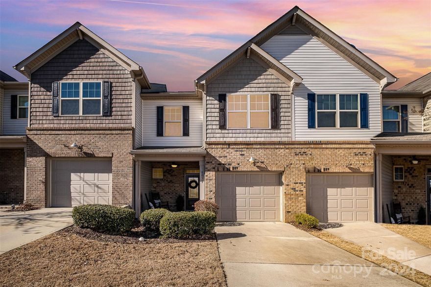 This lovely three-bedroom townhome boasts a fully-fenced private backyard, with a covered patio, that backs up to a wooded area. The main floor features granite countertops, a breakfast bar, stainless steel appliances, and a spacious pantry. The open dining area and family room with gas fireplace offer ample living space. The upper level includes a large primary bedroom and adjoining bath, a walk-in closet, two secondary bedrooms, separate full bath, and laundry room.  Recently painted, this home is truly move-in ready. With its proximity to the pool, mailboxes, and neighborhood pocket park, this townhome holds an unbeatable location within the complex. Shopping and dining options conveniently located nearby, including the Promenade at Carolina Reserve, add to this townhome's desirability.