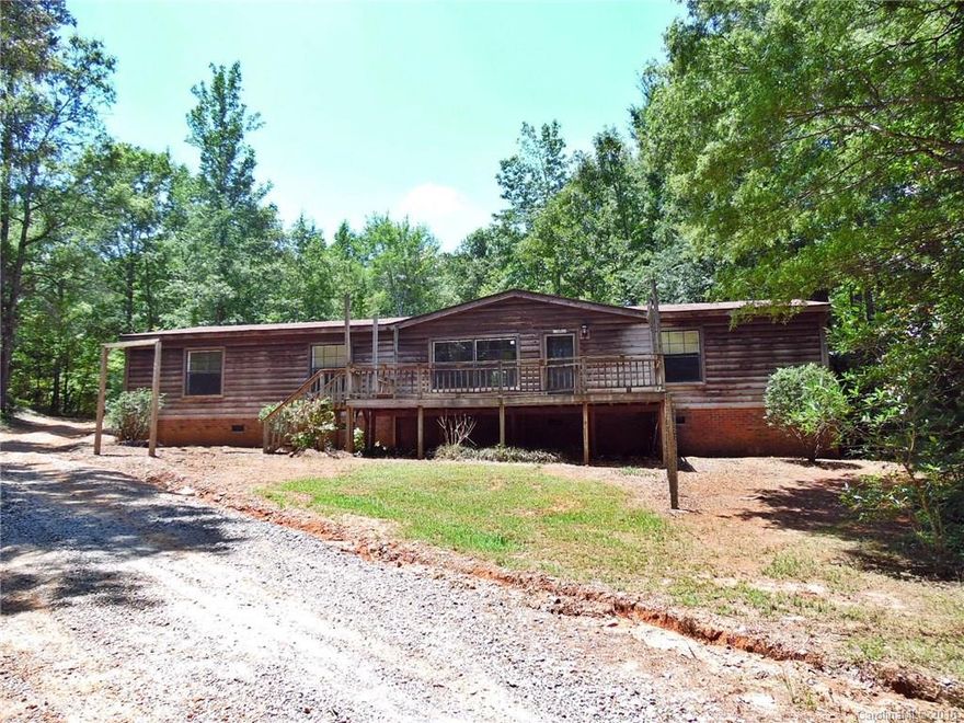 Privacy abounds in this doublewide mobile home on 4 acres of wooded surroundings! With loads of potential, this home features a large kitchen, living and den combo with fireplace, formal dining, and nice sized bedrooms. Master bath has a separate tub and shower, plus double sinks. Large deck to enjoy the peaceful sounds of nature. Strongly encouraged that offers include proof of funds/pre-approval & is required for seller's final acceptance.