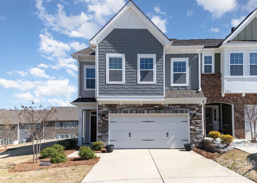 Move in ready end-unit townhome in the sought-after Paddlers Cove community! This light-filled home offers an open, airy floor plan and a well appointed kitchen featuring stainless steel appliances, granite countertops, a tile backsplash, gas cooktop, and an oversized island with custom leg detailing and plenty of seating—perfect for gathering and entertaining. The spacious living area offers a cozy gas fireplace, while the guest bathroom includes a dual-sink vanity for added comfort and functionality. Step outside to your private, partially fenced back patio—perfect for relaxing or entertaining. As an end unit, enjoy extra natural light and enhanced privacy. Residents of Paddlers Cove enjoy access to a community pool, open-air pavilion, and scenic walking, hiking, and biking trails. Conveniently located near Lake Wylie and an easy commute to Charlotte, this home is also zoned for top-rated Clover schools. With stylish finishes and a functional layout, this townhome perfectly blends comfort, convenience, and location.