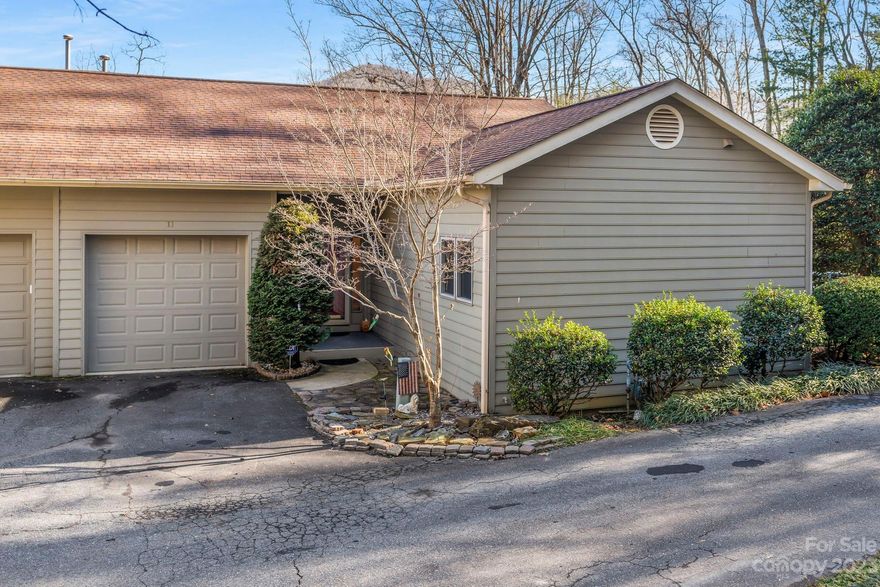Perched atop a quaint hill, this corner-lot townhome offers effortless main-level living with mountain views, high ceilings, and a convenient location just 10 mins to both downtown Asheville & Black Mtn, and 1.5 mi. to the Blue Ridge Pkwy and VA Hospital. Open & bright floorplan is inviting and flexible. Kitchen features two-tiered engineered stone counters perfect for serving & entertaining. Light-filled living room complete with bay window, cozy gas log fireplace, & built-in shelving. Primary bedroom accompanied by ensuite bathroom and walk-in closet. Enjoy views & fresh air from your back deck or lounge poolside in the summer. Ample parking with one-car garage, driveway, and nearby guest spots. River Knoll is an established private community with no city taxes and covers exterior maintenance, groundskeeping, pool, pond, water & sewer, garbage & recycling, road maintenance, and more. Newer HVAC system (2020). This charming home is competitively priced and awaits your personal touch!