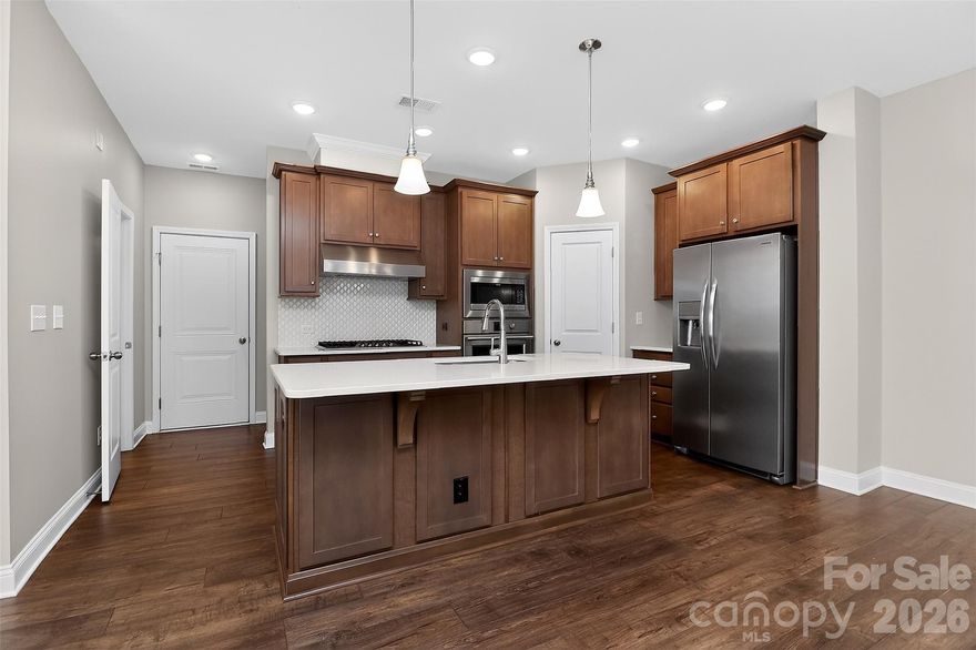 Welcome home to Chadwick Park! Enjoy the natural light in this end-unit townhome, which features 3 bedrooms, 2.5 bathrooms, and a 2-car garage with an extended parking pad. Upgrades include hardwoods on the main level and up the stairs. Freshly painted throughout and new carpet. Frigidaire Professional oversized gas range, oven, dishwasher, and microwave. Stainless Steel Fridge conveys as well. Beautiful quartz countertops, tile backsplash and oversized island. Corner pantry for ample storage. Upstairs is a loft area currently used as a second living room, 2 guest bedrooms, and the primary suite. The laundry room and hookup is also upstairs and oversized as well. Primary Suite features a generous bedroom and walk-in closet. Primary bathroom features dual sinks, quartz countertops, a linen closet, a shower, and a separate water closet. HOA maintains the beautiful landscaping and downtown Pineville is just one block away! Enjoy Waterbean Coffee in the morning on Main Street and wind down after work with a glass of wine at Margaux's Wine, Pizza & market. This townhome is set in a village-like setting with so much downtown charm, yet minutes to all of Uptown Charlotte's culture, Blue Line Light rail/ I-485 Station, airport and major highways.