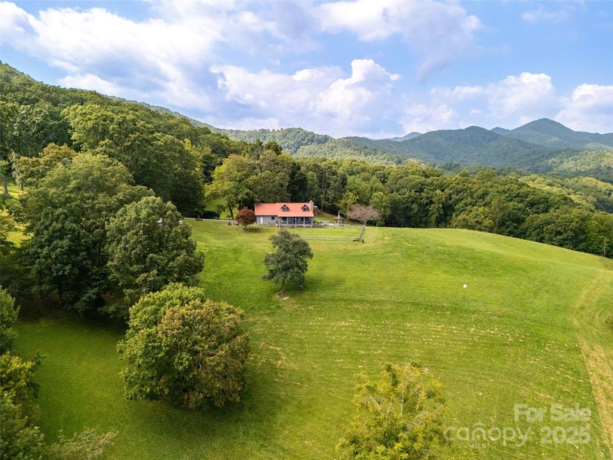A once-in-a-lifetime mountain retreat awaits at 50 Holland Ridge Drive in Candler, NC! Perched atop more than 44 acres of rolling pasture, open meadow, and tranquil forest, this storybook log home captures breathtaking long-range mountain views and offers unmatched privacy just 20 minutes from downtown Asheville. The custom-crafted residence blends rustic charm with timeless craftsmanship, featuring warm wood interiors, inviting great room centered around a stone fireplace, three spacious bedrooms and two full baths offer restful retreats with an authentic mountain-lodge feel.

Step outside to discover an outdoor paradise. Multiple covered porches and decks overlook lush pastures and wooded ridges, ideal for morning coffee, sunset views, or starlit evenings. The property’s 60x42 Morton metal building with bathroom and spacious block garage/workshop provide incredible flexibility for a home business, hobby farm, or private compound. A new greenhouse and charming chicken coop enhance the self-sufficient lifestyle, while internal trails and open spaces invite exploration, recreation, and endless outdoor enjoyment.

Despite its peaceful seclusion, this estate is conveniently close to everyday essentials, restaurants, and shopping. Whether envisioned as a family homestead, luxury retreat, or multi-use investment, 50 Holland Ridge Drive offers an extraordinary combination of natural beauty, functional space, and boundless potential—a true mountain sanctuary where serenity meets opportunity.