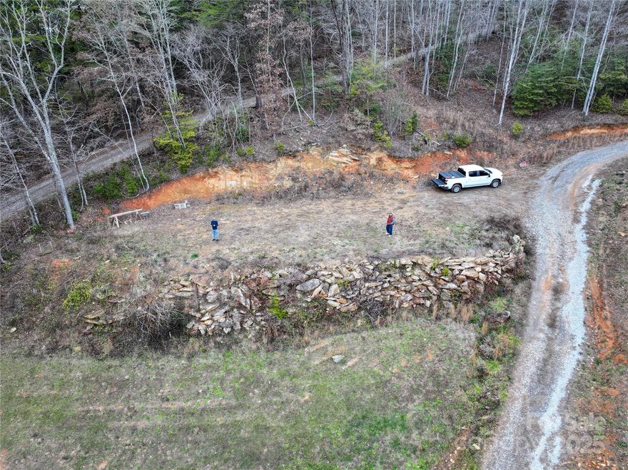 This exceptional property will not be available for long. It offers unrestricted land in the sought-after Deep Creek area, featuring a prime location with spectacular mountain views and easy access—just minutes from downtown Bryson City. Situated near the scenic Deep Creek and the entrance to Great Smoky Mountain National Park, this lot provides an ideal setting for a tiny home, yurt, modular residence, or other flexible housing options, with no restrictions in this small, welcoming neighborhood.

Property features include:

    Shared well (requires power connection to reservoir pump and house hookup)
    Two-bedroom septic system (each lot has its own tank, sharing drain field lines; designed for two bedrooms)
    Drain field located below the rock wall on this lot

Enjoy the tranquility of mountain living combined with convenient access to local amenities. This versatile, unrestricted land is perfect for those seeking a private retreat or a flexible building site near nature.