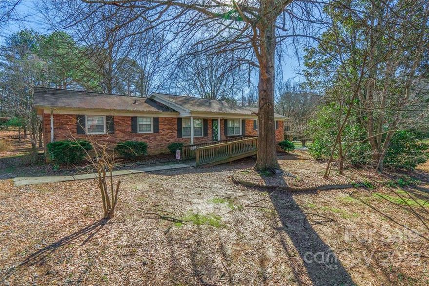 Lovely ranch home with covered front porch that is handicap accessible. Beautiful wooded front door and spacious living room. Kitchen and breakfast area is huge and offers stainless appliances that will convey.   Home has four roomy bedrooms and one full bathroom with a powder room in the primary bedroom. Outdoor space includes a large, shaded deck with wired workshop and the backyard has mature trees. Home is being sold “As-Is”.+ Laundry is located in the carport. *Buford schools.