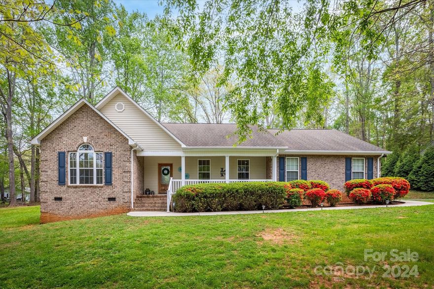 Under Contract.  Searching for a ready-to-move-in, single-level brick residence without city taxes? Located mere minutes from downtown Morganton on nearly an acre of land, this property boasts an array of desirable features. With an open split-bedroom layout, hardwood floors throughout (no carpet!), elegant arched doorways, and impressive vaulted and tray ceilings, this home exudes charm. The kitchen is adorned with solid surface counters and a pantry, while the living room offers a cozy stacked rock gas log fireplace. The master bedroom includes a double vanity and two walk-in closets. Outside, enjoy the serene outdoor spaces, including a covered front porch, covered back deck, and patio. Additional highlights include, recently fenced backyard, 10 x 12 outbuilding with concrete pad for storage, a spacious two-car garage with a utility room and a floored attic, as well as hot/cold water spigots by the garage, perfect for pet washing.