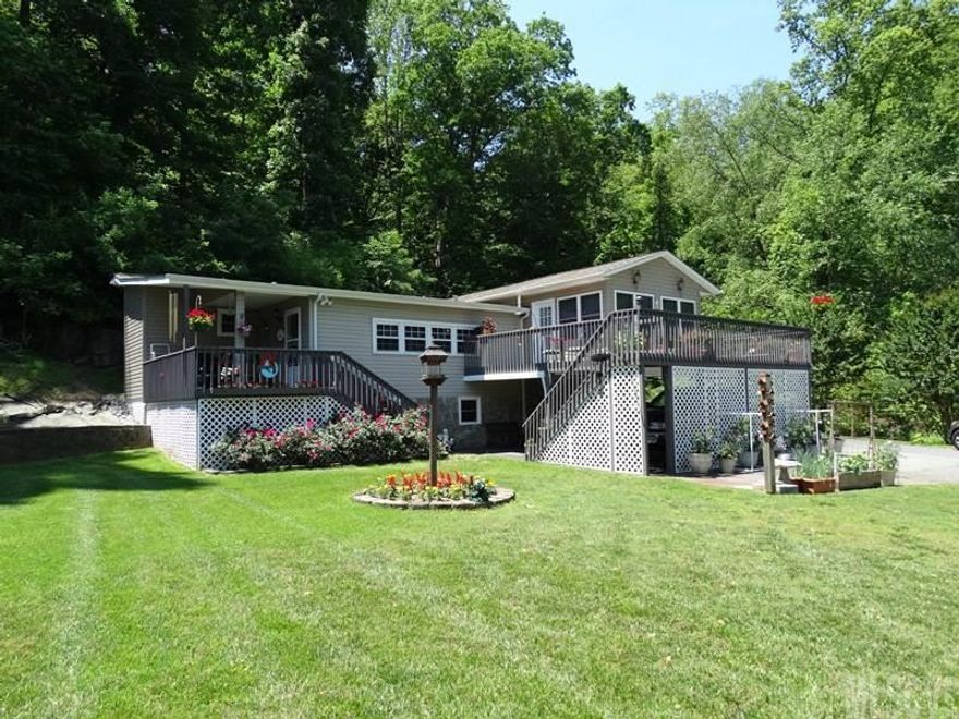 Calling all lake lovers! Mint condition 2BR/2BA home on LEVEL lake lot! Property includes attached carport parking for 3 cars plus a detached carport & storage building. Boat dock with seating plus covered boat slip. The house offers a covered porch deck & a large open deck. LR & DR with hdwd floors. Recently updated kitchen with Corian countertops, tile backsplash & new appliances. Walk-in pantry. MBR suite with access to sunroom with propane heater & window A/C. MBA with jetted tub, separate shower, laundry area & WIC. Security system, replacement windows & cellar type basement with exterior access.