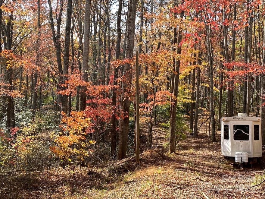 For Sale: RV and 5 acres with no restrictions in beautiful South Toe Community in Burnsville. 2009 Hampton Bay RV conveys at no cost (it is not connected to power or water at this time). Have yourself an instant get away! Paved road frontage. Lovely place for your home or camper. No well or septic in place. Current survey on file. White Oak Creek borders the southern line. Property adjacent to 4.75 acre Bird Creek Community Park which ensures from this property from neighboring development below. Don't let this one get away. This property is a short drive to the Blue Ridge Parkway, Mount Mitchell and Carolina Hemlocks! Please note White Oak Creek Road divides the property. Please see attached survey in pictures. The lower tract is accessed from White Oak Creek Road. The upper tract could have a road built but would be expensive. There is a right of way for the upper tract through Graystone Dr. The electrical lines are with French Broad Electric for anyone wanting information on cost to connect, etc.