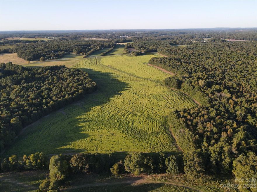 Welcome to a truly exceptional real estate opportunity in Locust, NC. This picturesque property encompasses a sprawling 188+/- acres, offering a blend of natural beauty and investment potential. Situated on both sides of Coley Store Road, this land is divided into 39+/- acres to the north and 146+/- acres to the south (over 1/2 mile of frontage on Coley Store Rd). There is a charming tenant-occupied farmhouse that adds a touch of history and character to the property. Sold "as-is," the farmhouse presents an opportunity for renovation and customization to your liking. Approximately 60 acres of fertile, open agricultural fields and 120+/- acres are graced with a lush canopy of timber, insuring both a harmonious coexistence with nature and a potential source of income from timber harvesting. The property is a haven for whitetail deer and turkey. There is a 1.75+/- acre farm pond. The AG fields are leased to a local farmer year to year. The farmer is open to continuing. Enrolled in PUV.