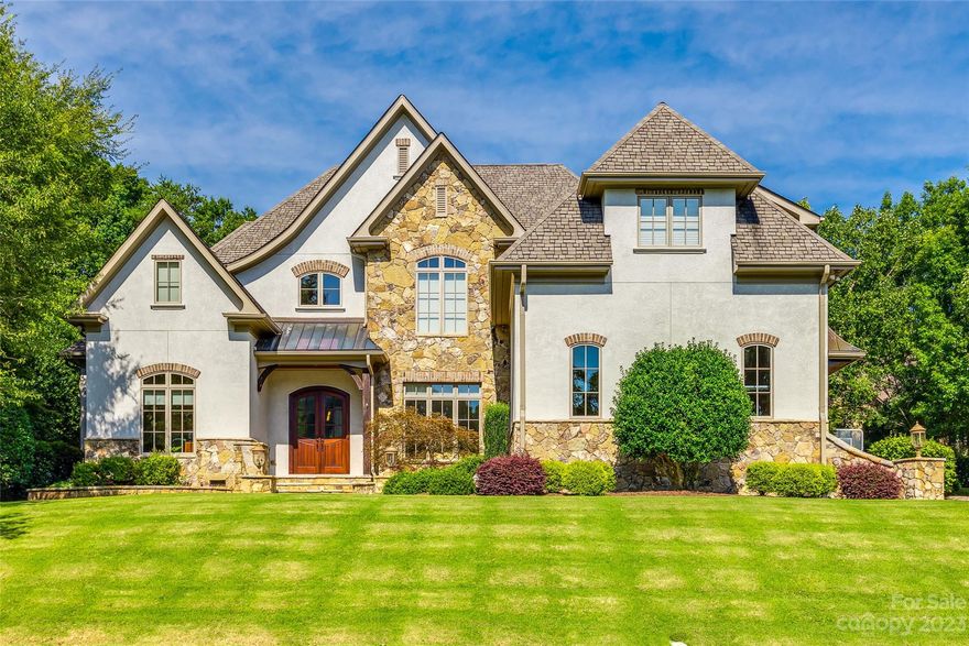 Ballantyne Country Club home beautifully crafted & accentuated with elegant finishes. Solid wood arched doors welcomes you to this gracious 5BR/4.5 BA home. Soaring foyer, 10ft ceilings, 8ft solid doors, arches & gleaming wood floors on main level. Chef's kitchen features Viking refrig, Mieler built-in expresso maker, Viking double ovens & cooktop.  Butler's pantry w/ wine cooler. Open GR has stone FP flanked w/ built-ins, wet bar, ice machine & beverage cooler - perfect for entertaining! Primary bedroom located on main level has double tray w/cove lighting.  Luxurious bath adjoins to fitness room. Upper level has 2 BR ensuites and additional 2 BRs. with shared bath. 2 large bonus room spaces that provides flex space for recreation/media/play. Walk-in & up attic storage. Incredible oversized screen porch w/ stone fp and built-in grilling area. Private/fenced rear yard. 3 car garage. Landscape lighting & irrigation. Ballantyne living w/ restaurants, shopping &  upcoming amphitheater.