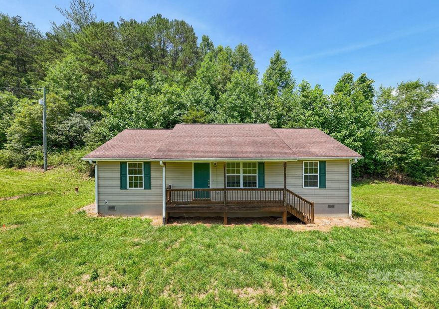 Charming 3-Bedroom Home near Lake Santeetlah! Nestled above a peaceful mountain and pastoral setting, this 3-bedroom, 2-bath home offers a desirable split floor plan with no HOA or deed restrictions with 1.16 acres of flat to gently rolling yard. The open-concept living areas feature durable luxury vinyl flooring, while the spacious kitchen boasts ample cabinet and counter space, a breakfast bar, and an adjoining dining area and laundry room. The large primary suite includes a private ensuite bath and a walk-in closet while two additional bedrooms and a second bath are thoughtfully positioned on the opposite side of the living room for added privacy. Relax on the covered front porch and take in the serene surroundings, or take advantage of the nearby USFS public boat launch—just under a mile away—leading to the breathtaking waters of Lake Santeetlah.